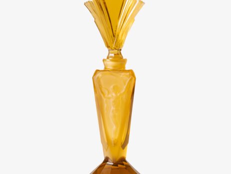Large Art Deco German perfume bottle in satin amber glass, 1930 – pressed glass with figurative relief panels and faceted fan-shaped stopper Large German Art Deco perfume bottle in satin-finished pressed amber glass, c. 1930, with figurative relief panels of nude female figures in different poses, faceted geometric base and tall fan-shaped stopper; height 29 cm / 11.42 in, width 9.5 cm / 3.74 in.