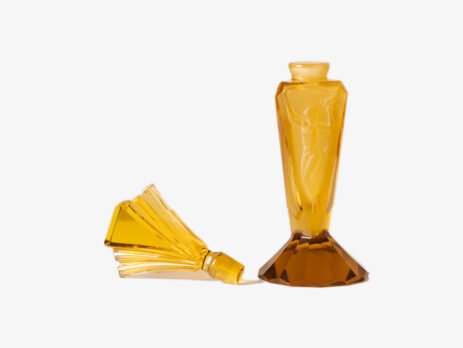 Large Art Deco German perfume bottle in satin amber glass, 1930 – pressed glass with figurative relief panels and faceted fan-shaped stopper Large German Art Deco perfume bottle in satin-finished pressed amber glass, c. 1930, with figurative relief panels of nude female figures in different poses, faceted geometric base and tall fan-shaped stopper; height 29 cm / 11.42 in, width 9.5 cm / 3.74 in.