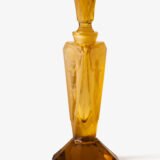 Large German Art Deco perfume bottle in satin-finished pressed amber glass, c. 1930, with figurative relief panels of nude female figures in different poses, faceted geometric base and tall fan-shaped stopper; height 29 cm / 11.42 in, width 9.5 cm / 3.74 in.