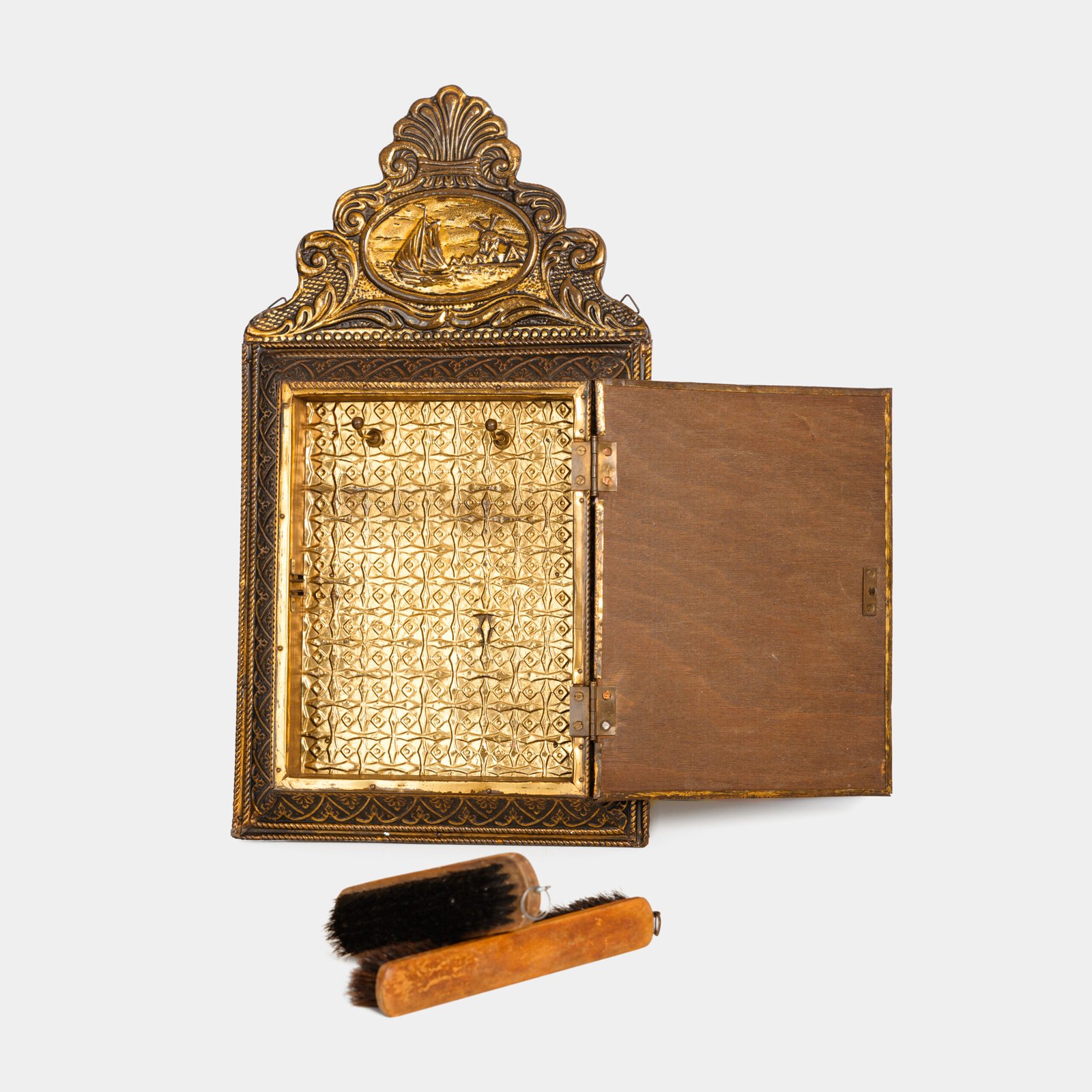 Dutch Mirror Cabinet in embossed brass with windmill motif, beveled mirror door and interior brushes, circa 1890–1920.