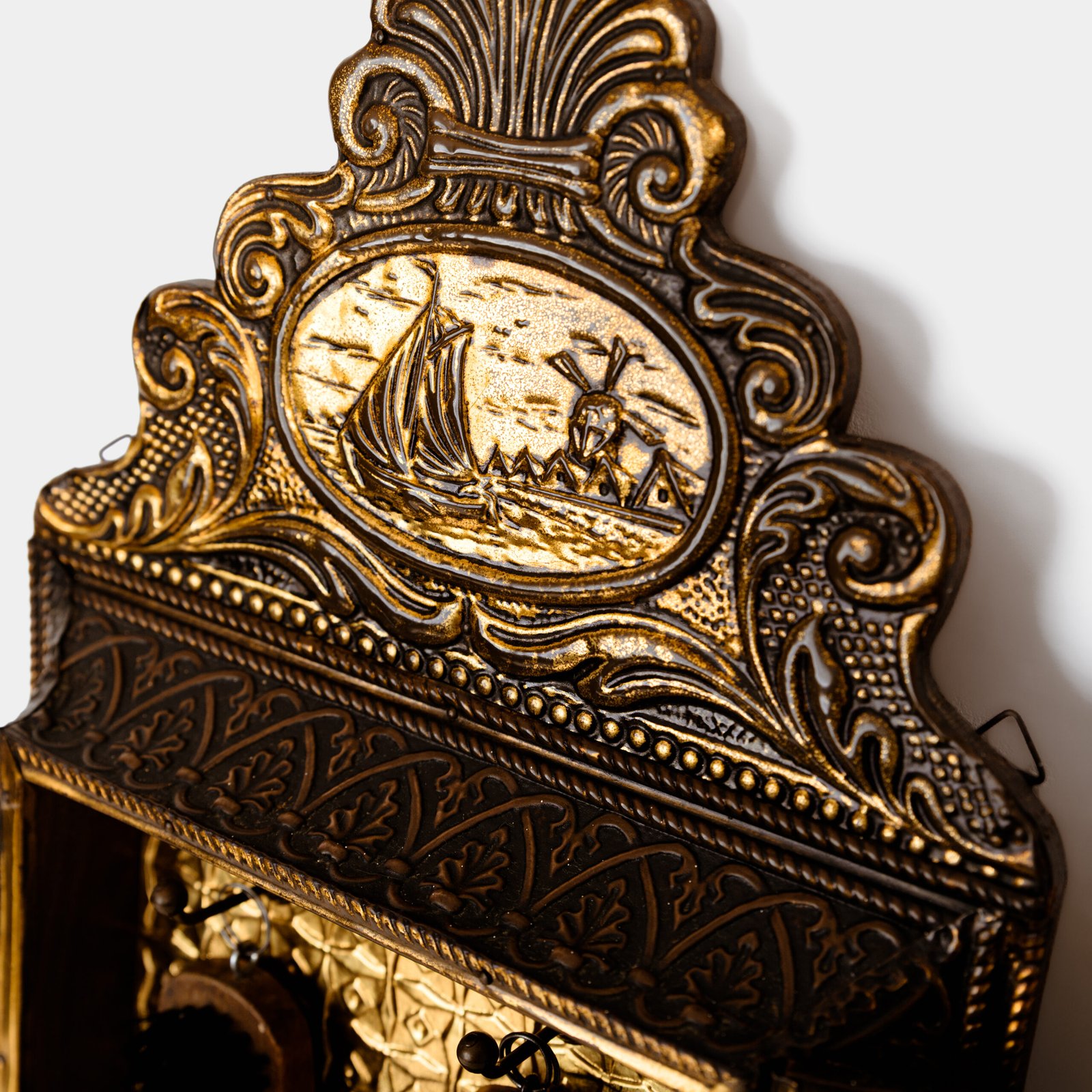 Dutch Mirror Cabinet in embossed brass with windmill motif, beveled mirror door and interior brushes, circa 1890–1920.