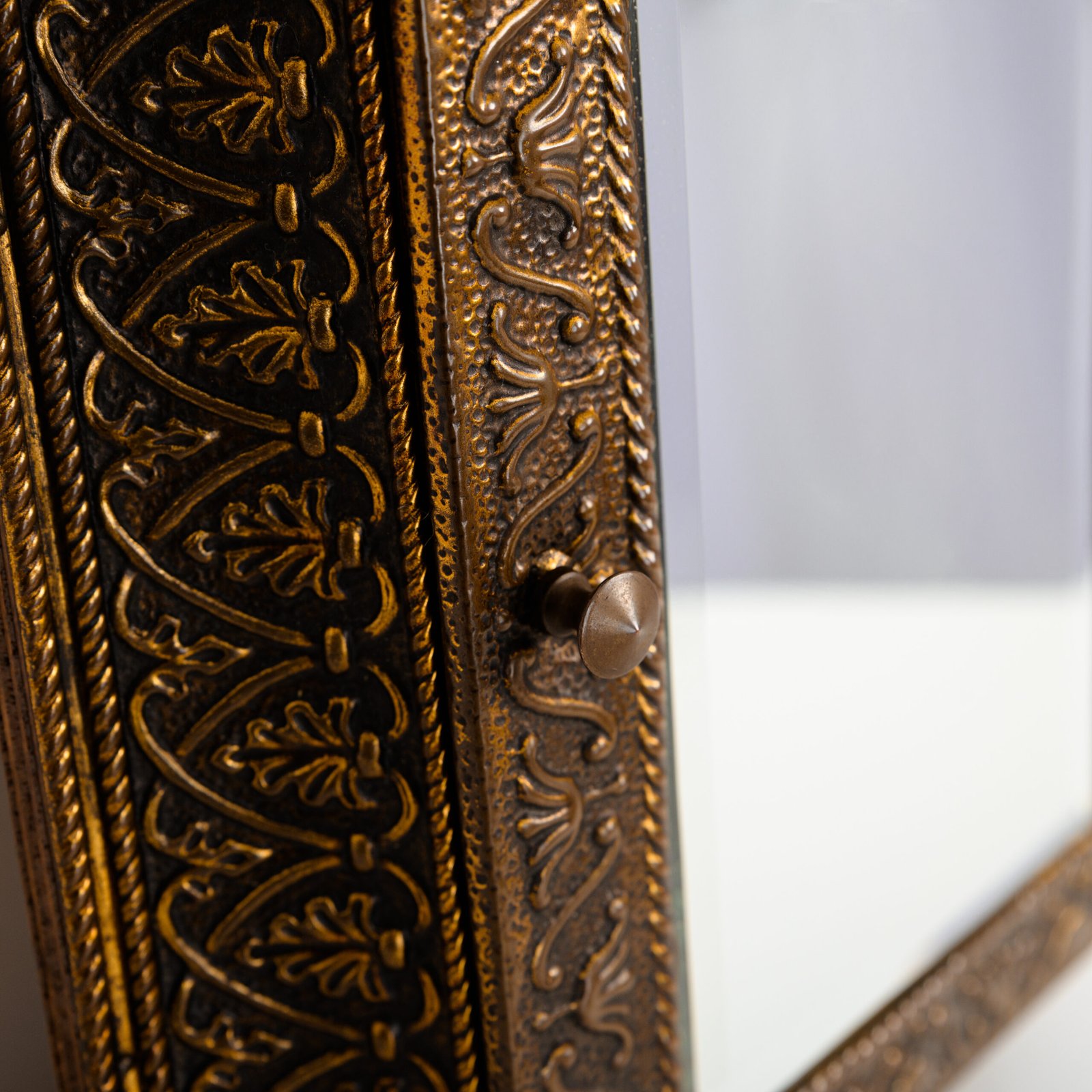 Dutch Mirror Cabinet in embossed brass with windmill motif, beveled mirror door and interior brushes, circa 1890–1920.