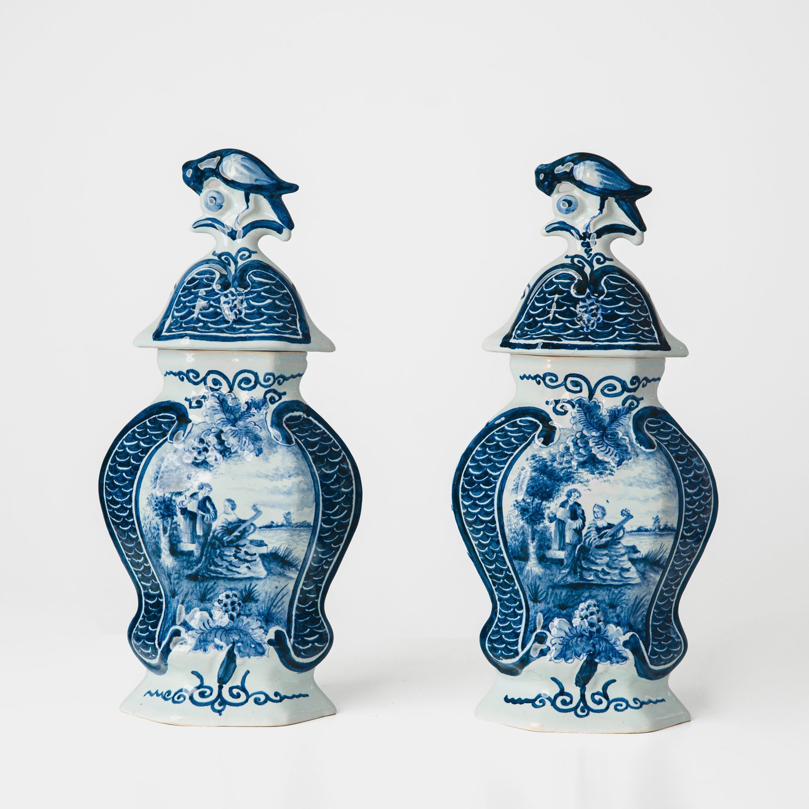 FOTOLATENT-jarrones001-hd Antique Delft Vases in cobalt blue with lid and bird finial, hand-painted hexagonal bodies with Dutch scenes and blue underglaze mark on the base.