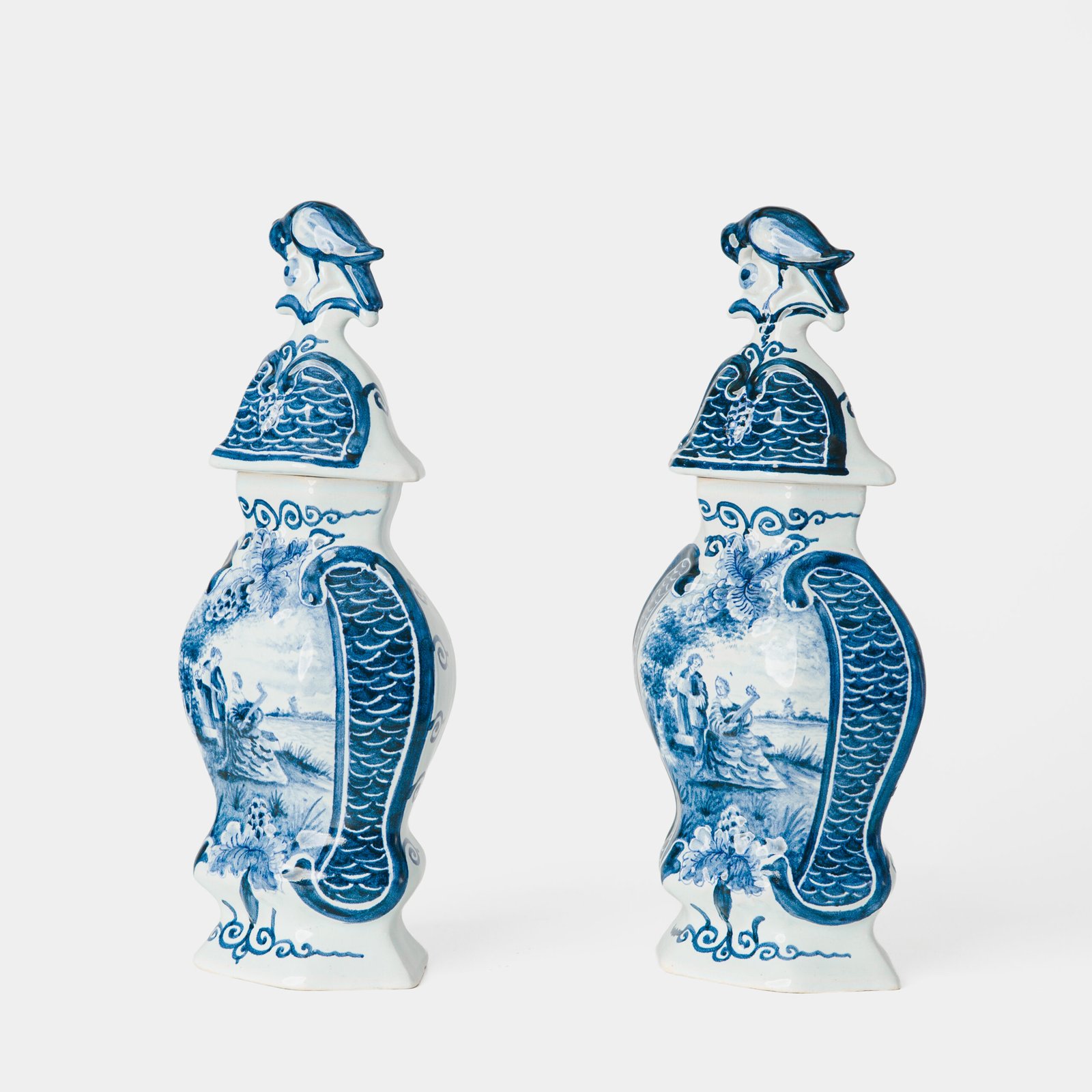 Antique Delft Vases in cobalt blue with lid and bird finial, hand-painted hexagonal bodies with Dutch scenes and blue underglaze mark on the base.