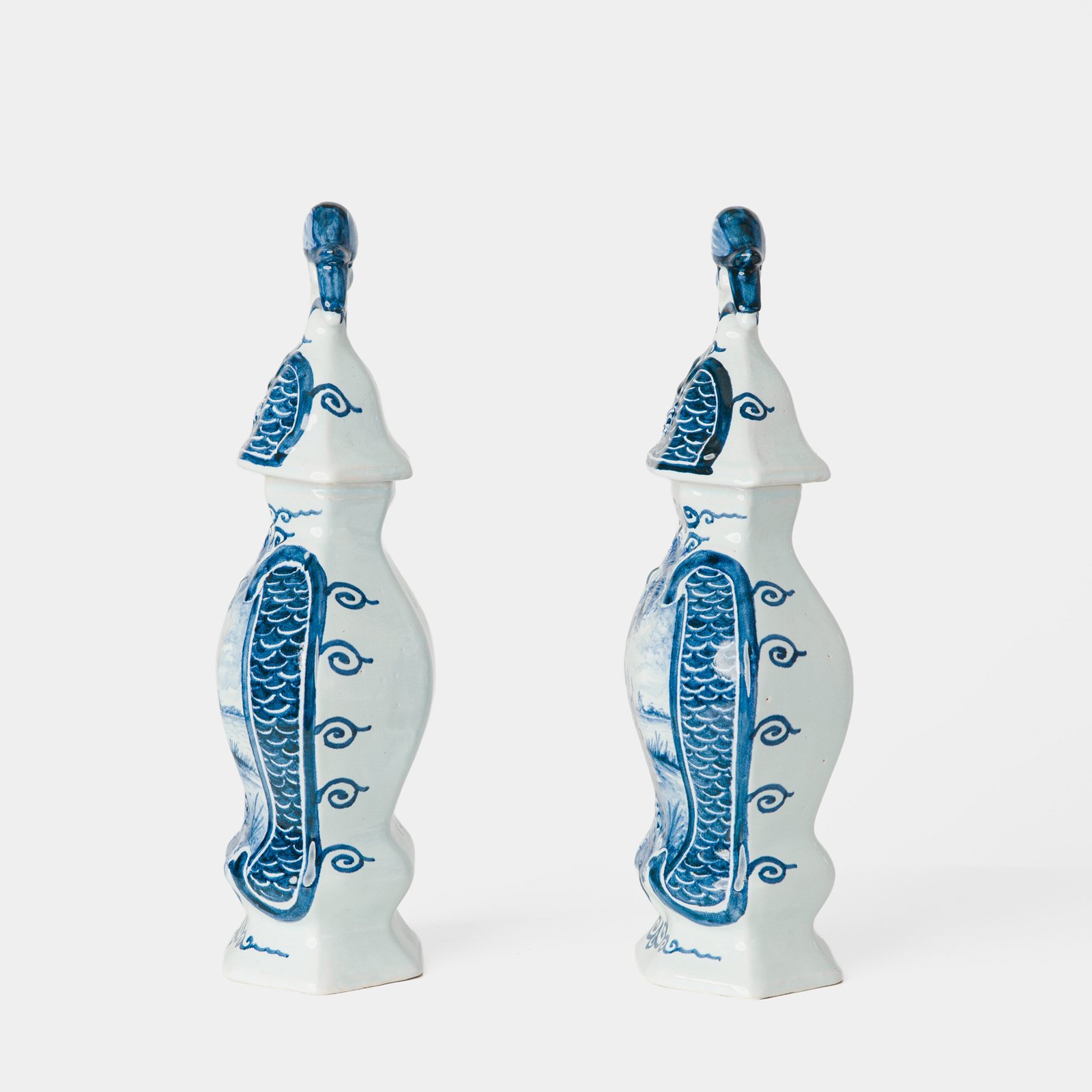 Antique Delft Vases in cobalt blue with lid and bird finial, hand-painted hexagonal bodies with Dutch scenes and blue underglaze mark on the base.