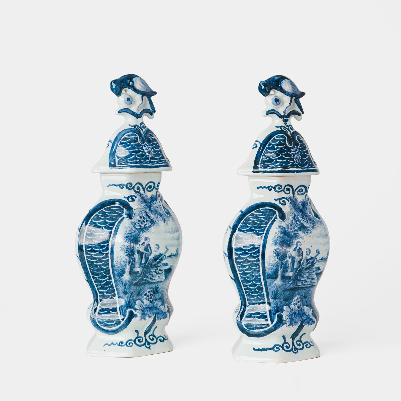 Antique Delft Vases in cobalt blue with lid and bird finial, hand-painted hexagonal bodies with Dutch scenes and blue underglaze mark on the base.