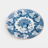 Antique Delft Plate from the early 18th century, crafted at the De Drie Porceleyne Flessies workshop, featuring the WK mark of Willem van der Kool and his widow Cornelia van Schoonhoven.