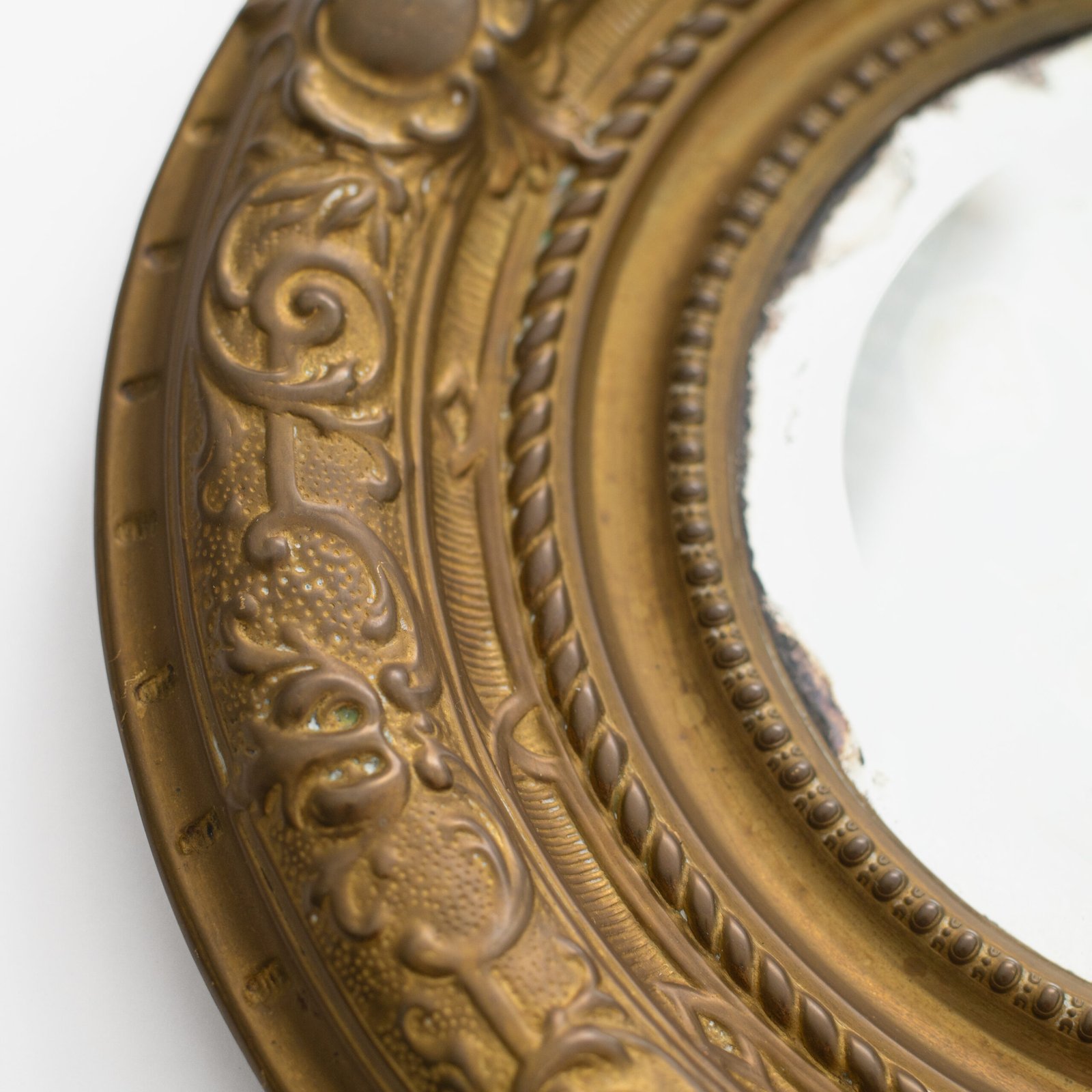 Antique Swedish Brass Mirror with repoussé Neoclassical frame and original beveled glass, 1890–1910.
