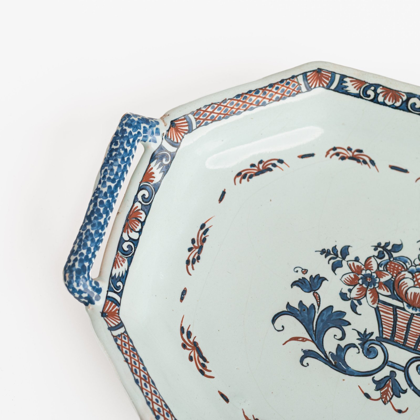 Rouen Faience Tray, an octagonal French banette from c. 1730 with two handles, a painted flower basket, and a red and blue galon rouennais border.