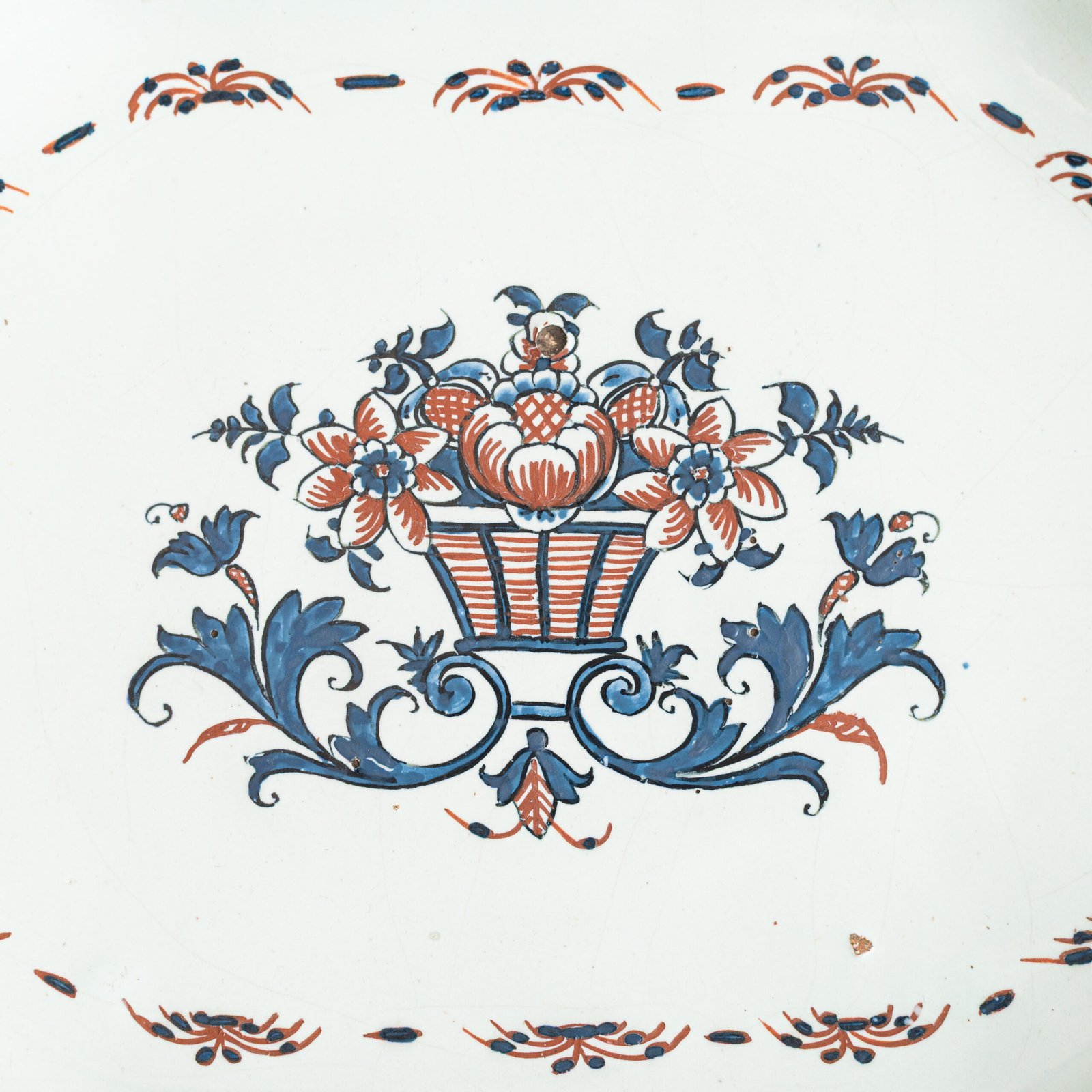 Rouen Faience Tray, an octagonal French banette from c. 1730 with two handles, a painted flower basket, and a red and blue galon rouennais border.