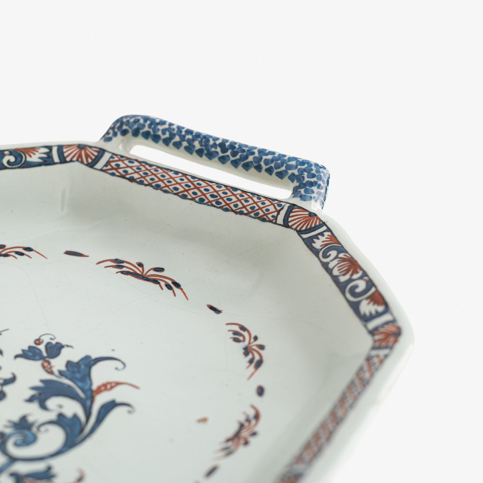 Rouen Faience Tray, an octagonal French banette from c. 1730 with two handles, a painted flower basket, and a red and blue galon rouennais border.