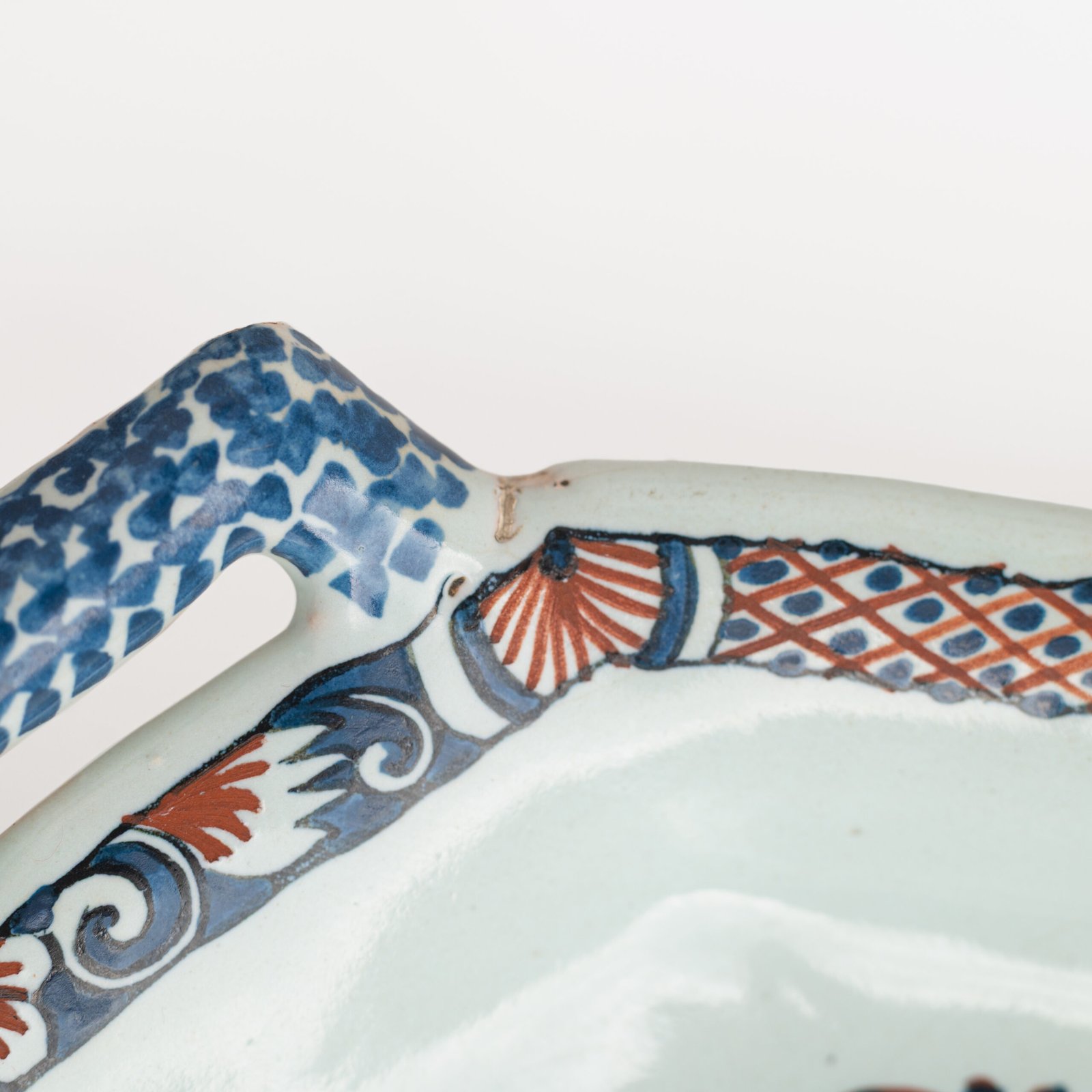 Rouen Faience Tray, an octagonal French banette from c. 1730 with two handles, a painted flower basket, and a red and blue galon rouennais border.