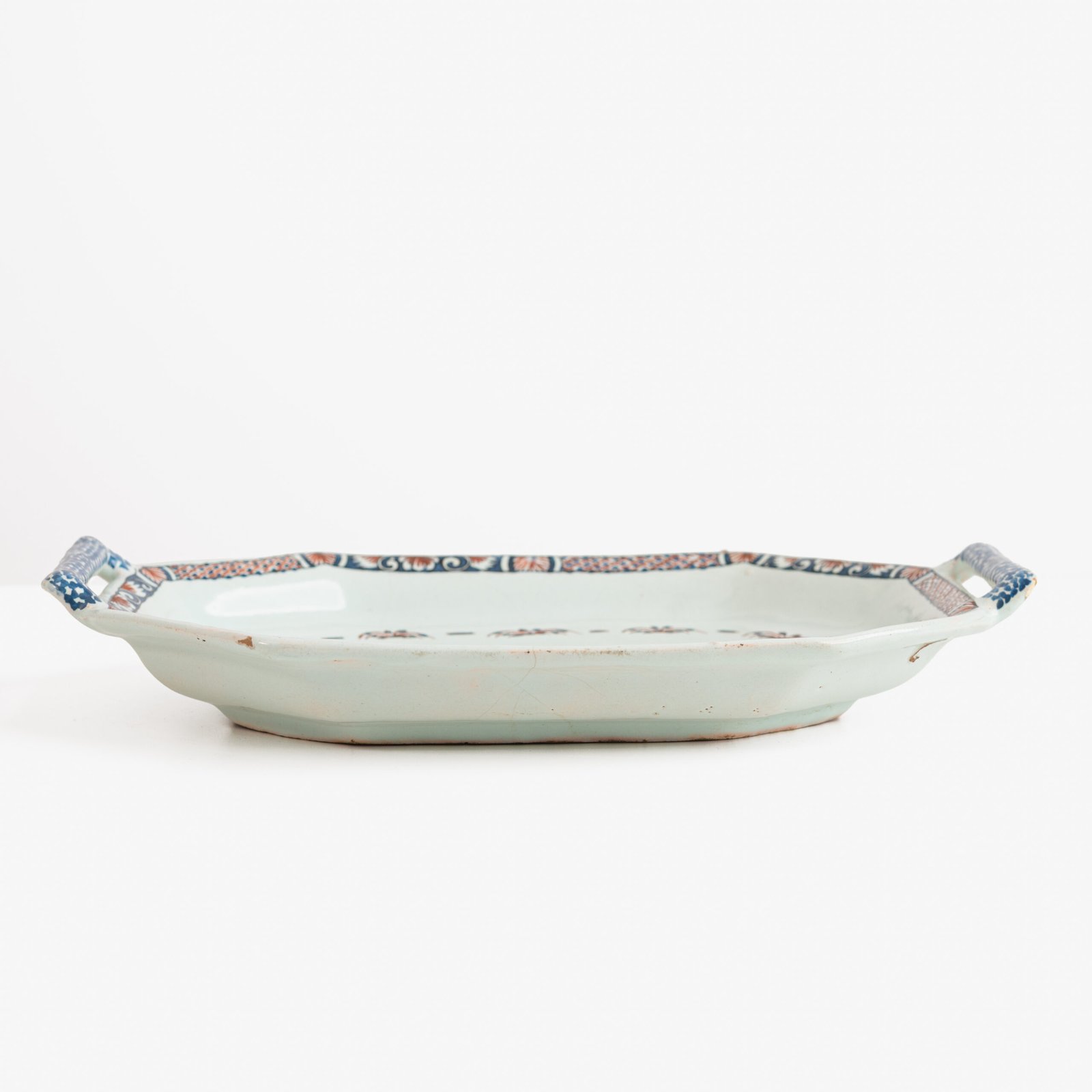 Rouen Faience Tray, an octagonal French banette from c. 1730 with two handles, a painted flower basket, and a red and blue galon rouennais border.