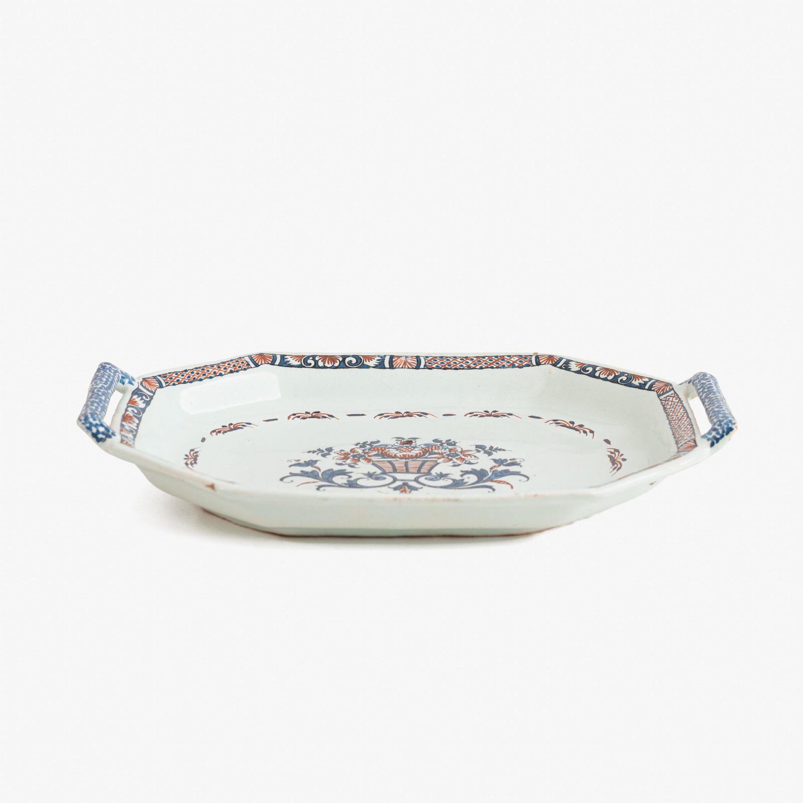 Rouen Faience Tray, an octagonal French banette from c. 1730 with two handles, a painted flower basket, and a red and blue galon rouennais border.