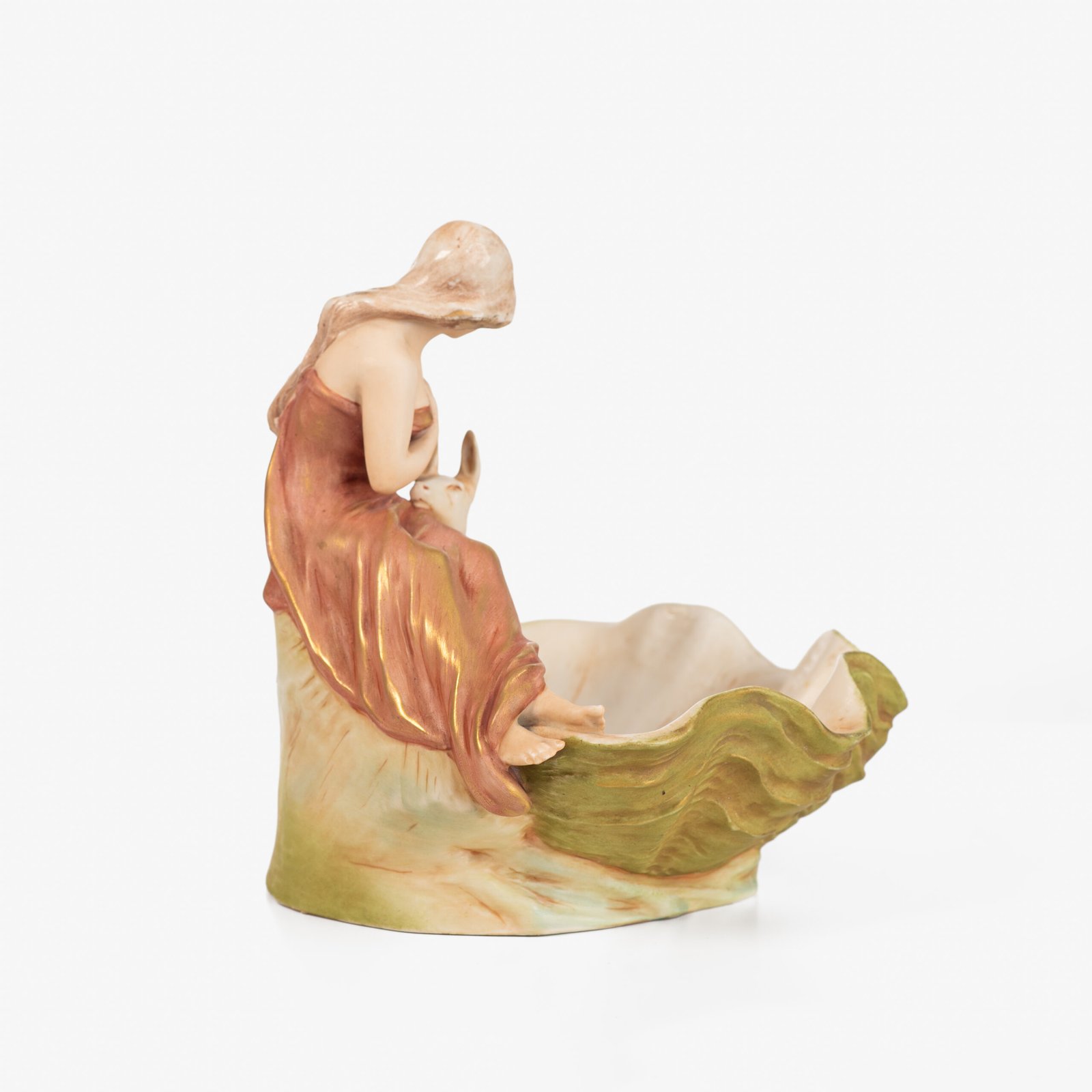 Royal Dux Art Nouveau porcelain centerpiece with a seated maiden and fawn beside a green shell-shaped bowl, hand-painted with gilt highlights, circa 1920–1930.