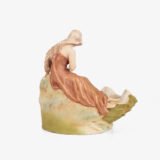 Royal Dux Art Nouveau porcelain centerpiece with a seated maiden and fawn beside a green shell-shaped bowl, hand-painted with gilt highlights, circa 1920–1930.