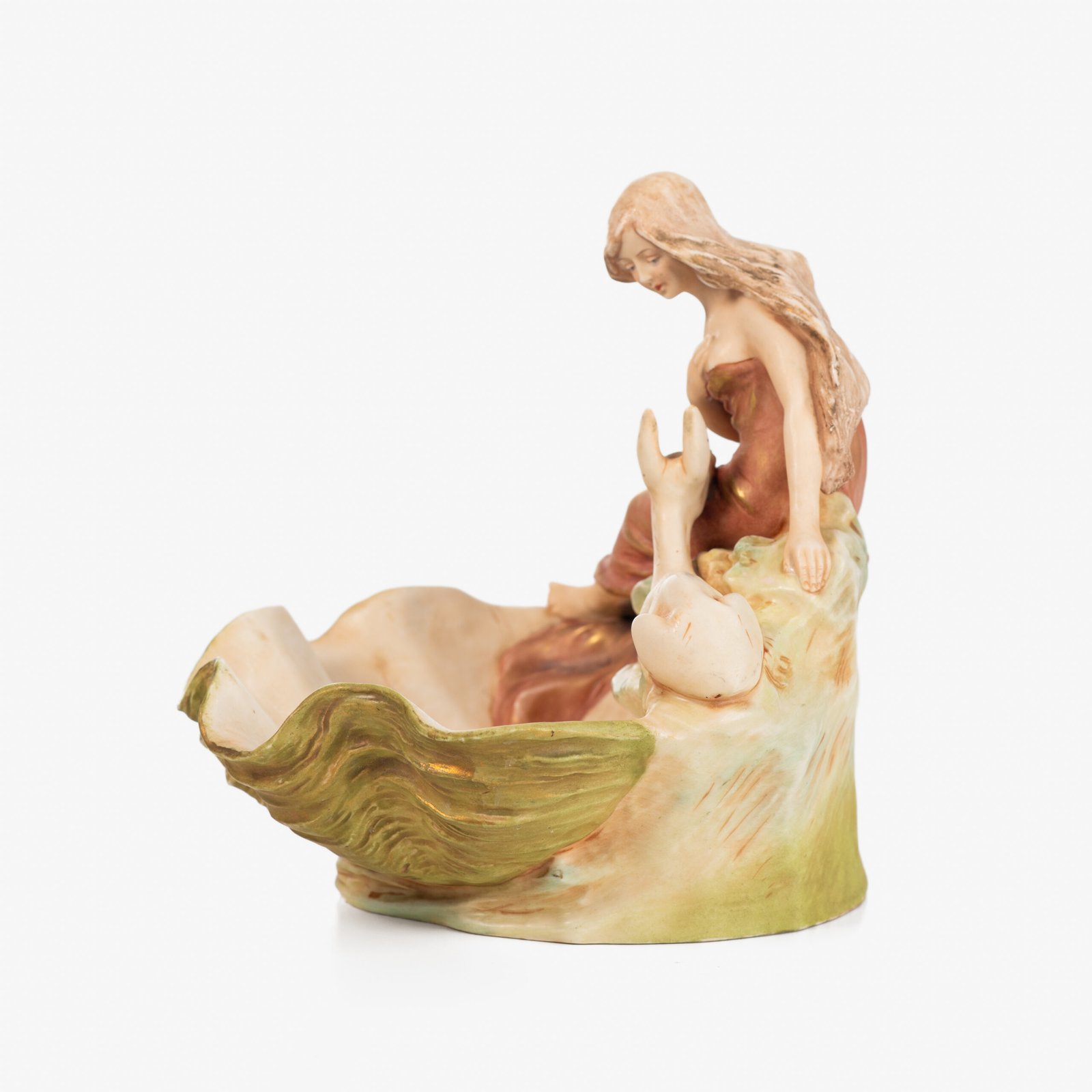 Royal Dux Art Nouveau porcelain centerpiece with a seated maiden and fawn beside a green shell-shaped bowl, hand-painted with gilt highlights, circa 1920–1930.