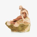 Royal Dux Art Nouveau porcelain centerpiece with a seated maiden and fawn beside a green shell-shaped bowl, hand-painted with gilt highlights, circa 1920–1930.