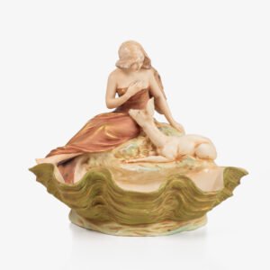 Royal Dux Art Nouveau porcelain centerpiece with a seated maiden and fawn beside a green shell-shaped bowl, hand-painted with gilt highlights, circa 1920–1930.