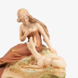 Royal Dux Art Nouveau porcelain centerpiece with a seated maiden and fawn beside a green shell-shaped bowl, hand-painted with gilt highlights, circa 1920–1930.