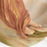 Royal Dux Art Nouveau porcelain centerpiece with a seated maiden and fawn beside a green shell-shaped bowl, hand-painted with gilt highlights, circa 1920–1930.