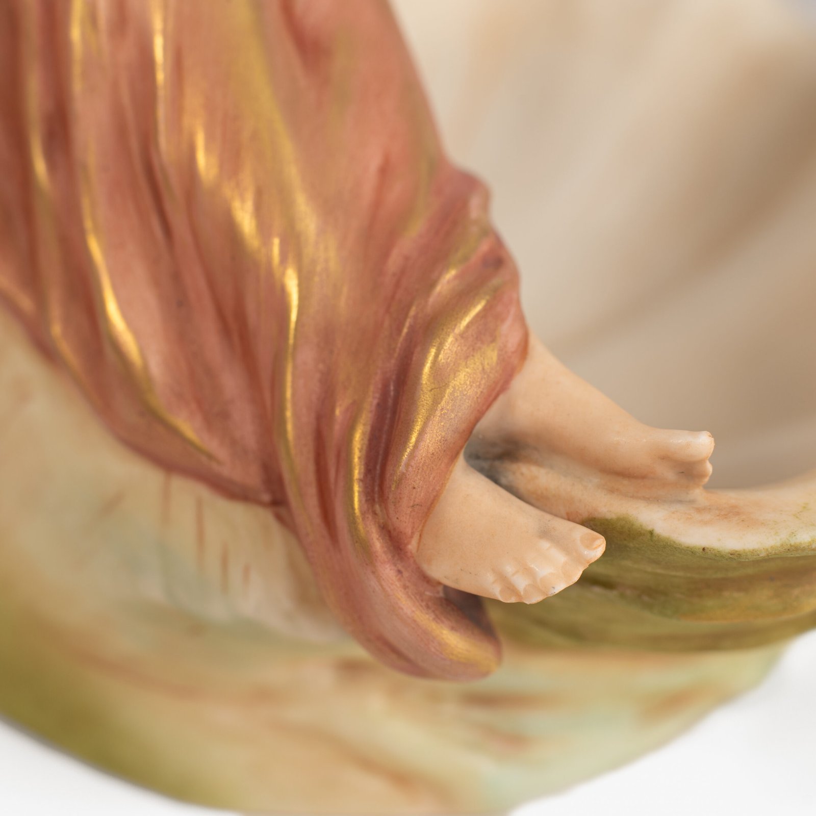 Royal Dux Art Nouveau porcelain centerpiece with a seated maiden and fawn beside a green shell-shaped bowl, hand-painted with gilt highlights, circa 1920–1930.