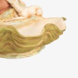 Royal Dux Art Nouveau porcelain centerpiece with a seated maiden and fawn beside a green shell-shaped bowl, hand-painted with gilt highlights, circa 1920–1930.