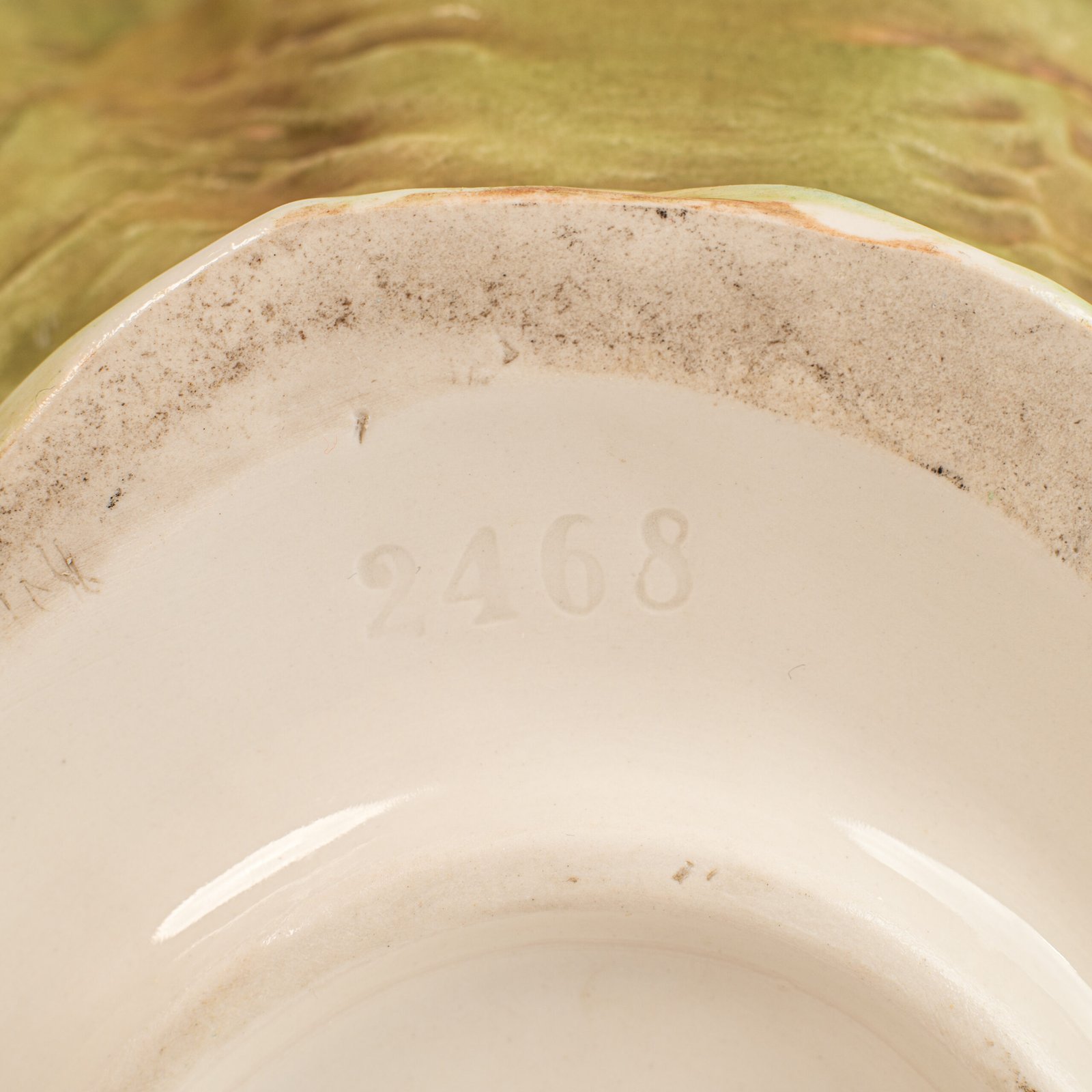 Royal Dux Art Nouveau porcelain centerpiece with a seated maiden and fawn beside a green shell-shaped bowl, hand-painted with gilt highlights, circa 1920–1930.