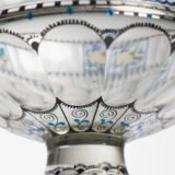 Bohemian Glass Compote, c. 1915, with hand-enamelled birds in scalloped blue panels, geometric glass cutting, gilt rim and a faceted foot decorated with black scrolls and blue leaves.