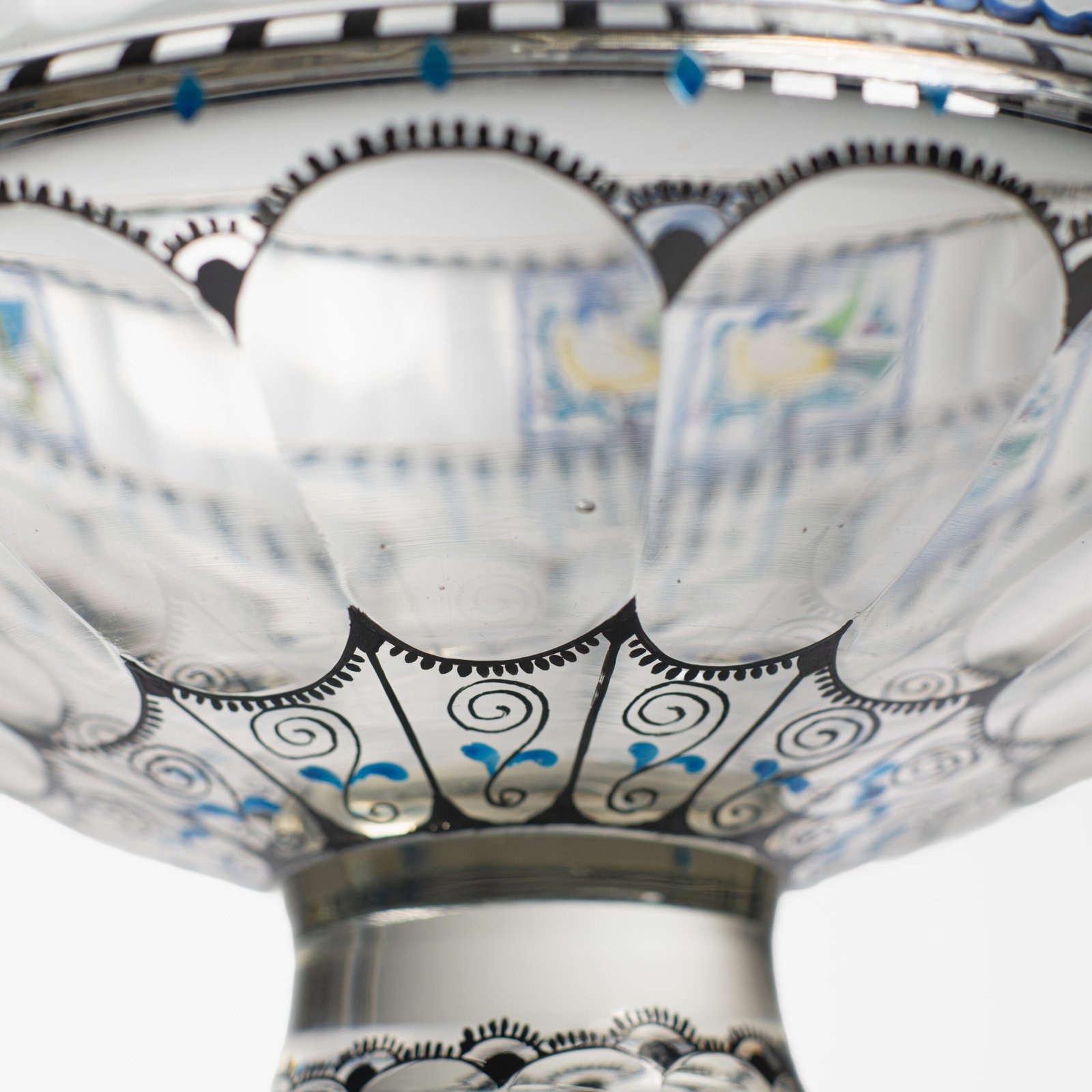 Bohemian Glass Compote, c. 1915, with hand-enamelled birds in scalloped blue panels, geometric glass cutting, gilt rim and a faceted foot decorated with black scrolls and blue leaves.