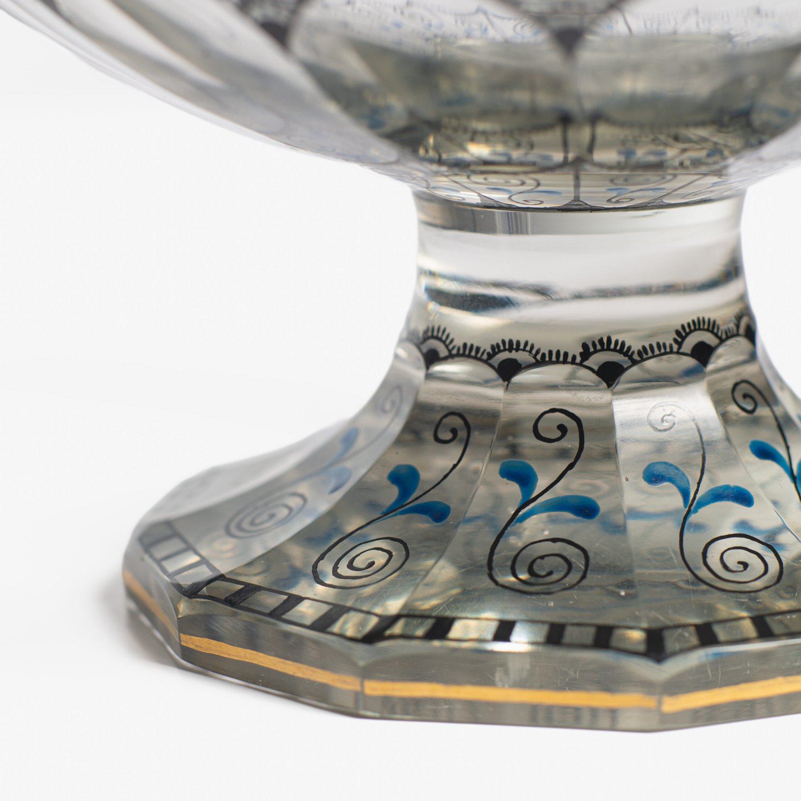 Bohemian Glass Compote, c. 1915, with hand-enamelled birds in scalloped blue panels, geometric glass cutting, gilt rim and a faceted foot decorated with black scrolls and blue leaves.