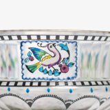 Bohemian Glass Compote, c. 1915, with hand-enamelled birds in scalloped blue panels, geometric glass cutting, gilt rim and a faceted foot decorated with black scrolls and blue leaves.