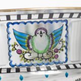 Bohemian Glass Compote, c. 1915, with hand-enamelled birds in scalloped blue panels, geometric glass cutting, gilt rim and a faceted foot decorated with black scrolls and blue leaves.